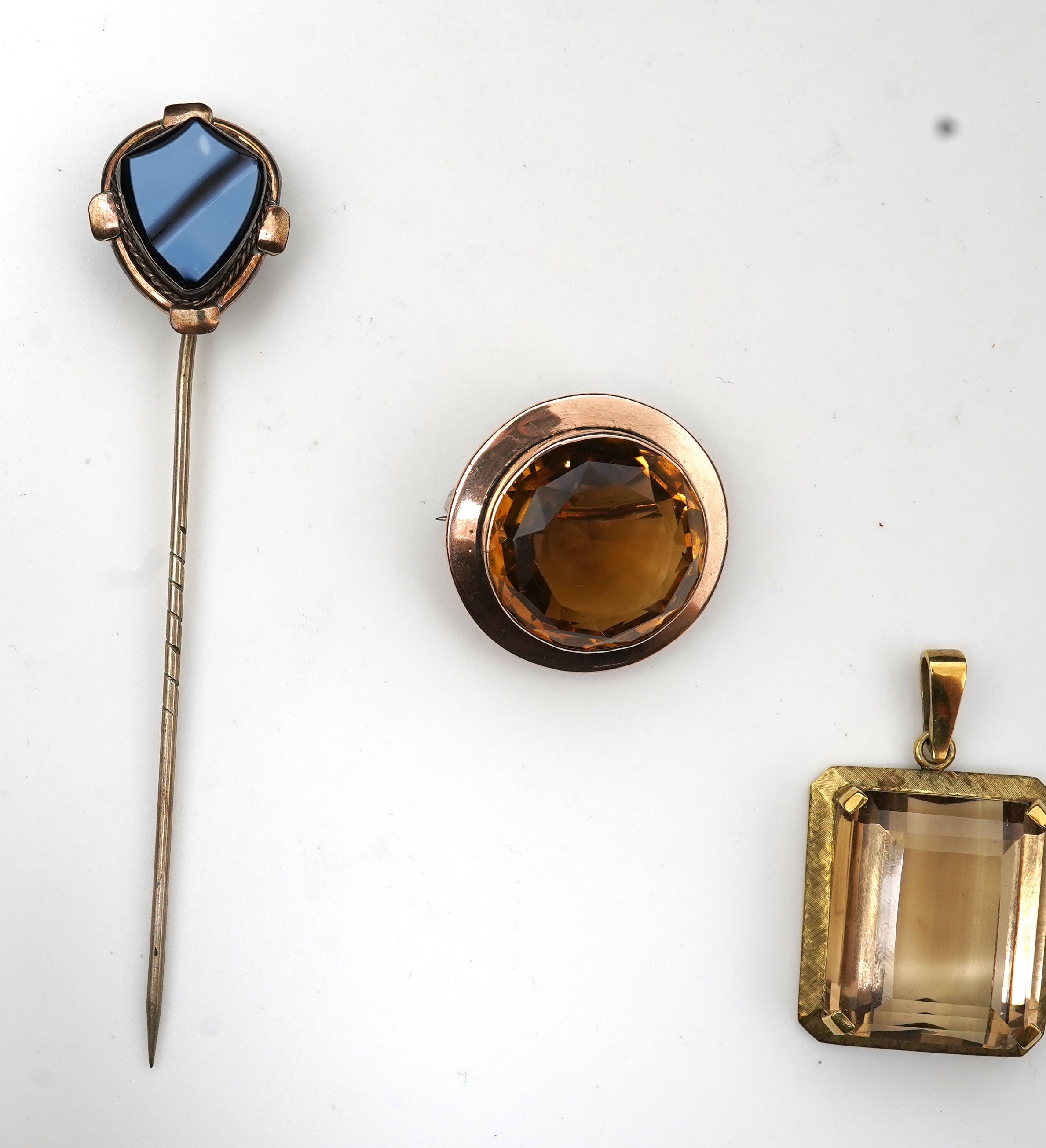 A citrine brooch and pendant, and onyx stickpin
